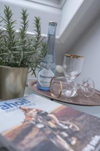 a table with a bottle and glasses and a magazine at Hotel Seehof Norderney OHG in Norderney