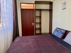 a bedroom with a bed and a wooden door at Kijani Kibichi Cottages in Naro Moru