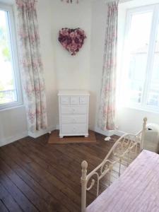 una camera da letto con un letto, un comò e due finestre di Montemboeuf centre Town House free wifi a Montembœuf Altre 23 foto
