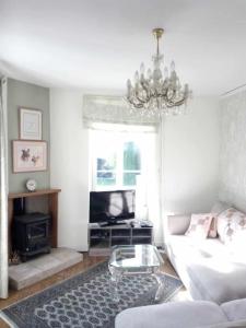 un soggiorno con un divano e un lampadario di Montemboeuf centre Town House free wifi a Montembœuf