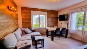 ein Wohnzimmer mit Sofa und Tisch in der Unterkunft F2* * * 80M DU LAC avec vue+terrasse+proche centre in Gérardmer