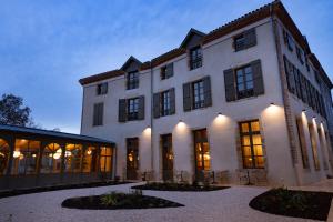 um grande edifício branco com muitas janelas em La Villa Serra - Appartements em Agen