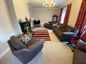 a living room with couches and a fireplace at Portinaghy House in Scairbh na gCaorach