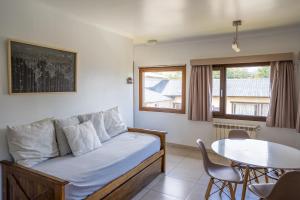 uma sala de estar com uma cama e uma mesa em Utaka Cabañas y Apartamentos em Ushuaia