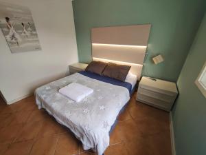 a small bedroom with a bed and a lamp at Vagueira Guest House & Beach Hostel in Aveiro