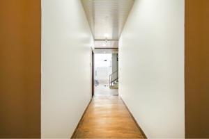 a long hallway with white walls and a wooden floor at FabExpress Dream paradise in Indore