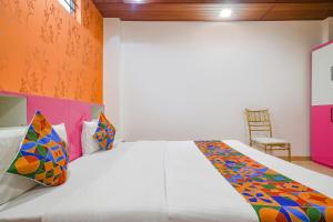 - une chambre avec un grand lit blanc et des oreillers colorés dans l'établissement FabExpress Dream paradise, à Indore
