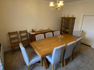 een eetkamer met een houten tafel en stoelen bij Portinaghy House in Scairbh na gCaorach