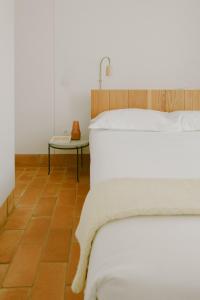 a bedroom with a white bed and a table at Casa Modesta in Olhão