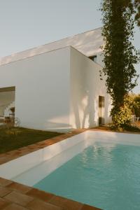uma piscina em frente a uma casa branca em Casa Modesta em Olhão