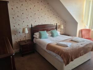 ein Schlafzimmer mit einem Bett mit zwei Kissen darauf in der Unterkunft Victoria Hotel in Portknockie