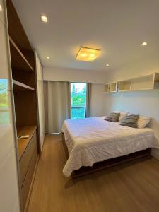1 dormitorio con cama y ventana grande en Santa Mônica Barra en Río de Janeiro