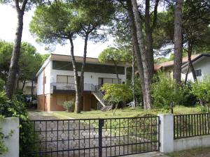 リニャーノ・サッビアドーロにあるApartments in Lignano 21670の塀と木のある家