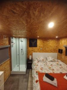 a bedroom with a bed and a glass shower at Le Cottage des Hortillonnages in Amiens
