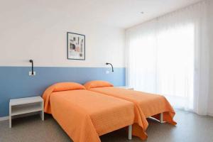 - une chambre avec un lit et une couverture orange dans l'établissement Apartment in Lignano Sabbiadoro 21778, à Lignano Sabbiadoro