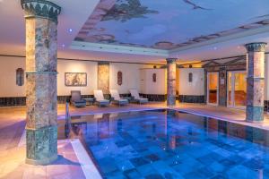 a pool in a hotel with columns and chairs at Häcker's Hotel in Bad Ems