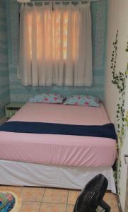 Off hostel floripa في فلوريانوبوليس: غرفة نوم بسرير مع نافذة وكرسي