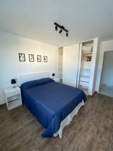 een slaapkamer met een blauw bed en 2 nachtkastjes bij Edificio Farfalle in La Plata
