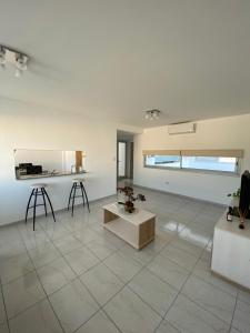 a living room with a tile floor and a table at Edificio Farfalle -Cochera incuida in La Plata