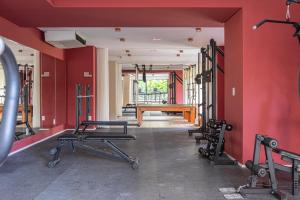 einen Fitnessraum mit roten Wänden, einer Bank und Gewichten in der Unterkunft NHC - Neohouse Campo Belo By Anora Spaces in São Paulo
