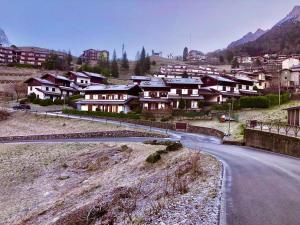 a group of houses on a hill next to a road at CASA VACANZE OLTRE IL COLLE BBQUEEN in Oltre il Colle