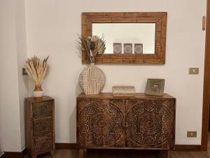 a mirror on top of a dresser with a vase at CASA VACANZE OLTRE IL COLLE BBQUEEN in Oltre il Colle