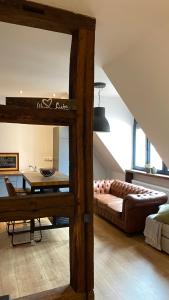 ein Wohnzimmer mit einem Sofa und einem Tisch in der Unterkunft Sonnenhof 1737 - Ferienzimmer & Apartments in Barbelroth