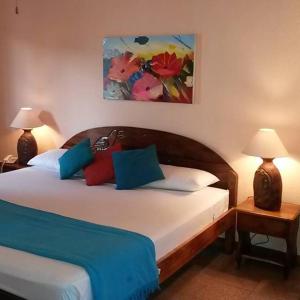 1 dormitorio con 1 cama con almohadas azules y rojas en Samara Beach Hotel, en Sámara