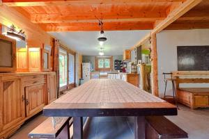 una gran mesa de madera en una habitación con cocina en Peaceful chalet near the ski slopes 8 people, en Fontrabiouse
