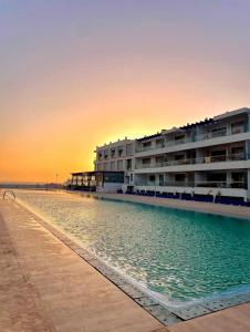 a hotel on the beach at sunset at Superbe appartement pieds dans l’eau in Aourir