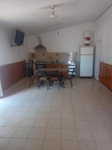 Habitación con mesas y cocina con nevera. en Casa el tala en Villa Santa Cruz del Lago