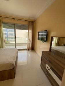 a bedroom with a bed and a flat screen tv at Superbe appartement pieds dans l’eau in Aourir