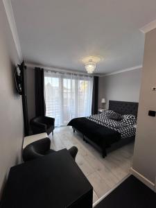 sypialnia z czarno-białym łóżkiem i krzesłem w obiekcie Saviano Mare Villa w mieście Międzyzdroje