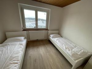 two beds in a room with a window at Ferien- und Monteurswohnung in Amstetten 