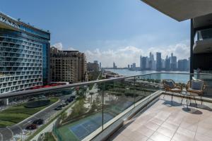 a balcony with two chairs and a view of the city at 3BR Oasis on Palm with Sea View, Private beach and Lazy River Access in Dubai