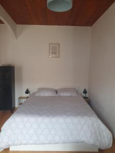 1 dormitorio con 1 cama con edredón blanco en Appartement meublé centre ville NYONS, en Nyons