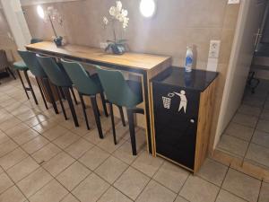 a bar with green chairs and a table with a sign at Gent Apt in Vienna +22 photos