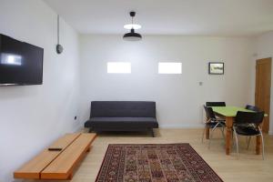 uma sala de estar com um sofá preto e uma mesa em Spacious modern one bedroom apartment em Galway