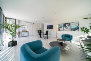 een woonkamer met een blauwe bank en stoelen bij Silver Park in Paphos City