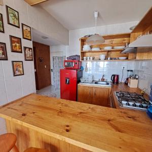 a kitchen with a red refrigerator and a wooden counter top at La Marina home in Concón