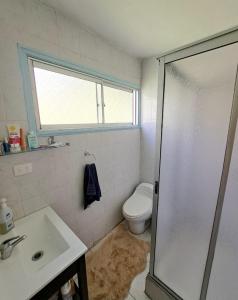 a bathroom with a toilet and a sink and a shower at La Marina home in Concón