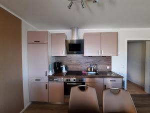 a kitchen with white cabinets and a stove top oven at Appartement 13 im Haus Dreisessel in Haidmühle