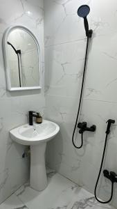 ein weißes Badezimmer mit einem Waschbecken und einem Spiegel in der Unterkunft شقة صالة وغرفة نوم في حي حطين in Riad