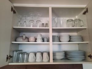 a cabinet filled with plates and glasses and dishes at Appartement 13 im Haus Dreisessel in Haidmühle