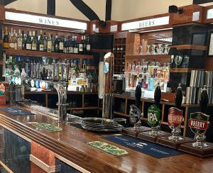 a bar with a lot of bottles of alcohol at The Fishmongers Tavern in Sheringham