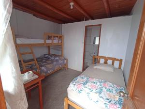a bedroom with two bunk beds and a table at El Paraíso in Huarmey