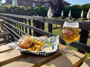a basket of food and a glass of beer on a table at The Fishmongers Tavern in Sheringham
