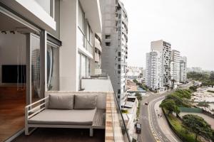 a couch on the balcony of a building at InkaHuset Miraflores Oceanfront in Lima