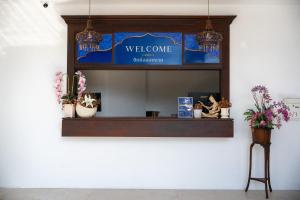 a welcome sign on a wall with potted plants at Singharaj Boutique Hotel in Chiang Mai