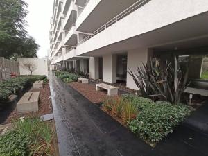 a building with a row of plants and benches at Moderno y equipado estudio en Los Dominicos in Santiago